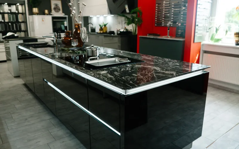Design-Küche mit schwarzer Hochglanz-Insel und Granit